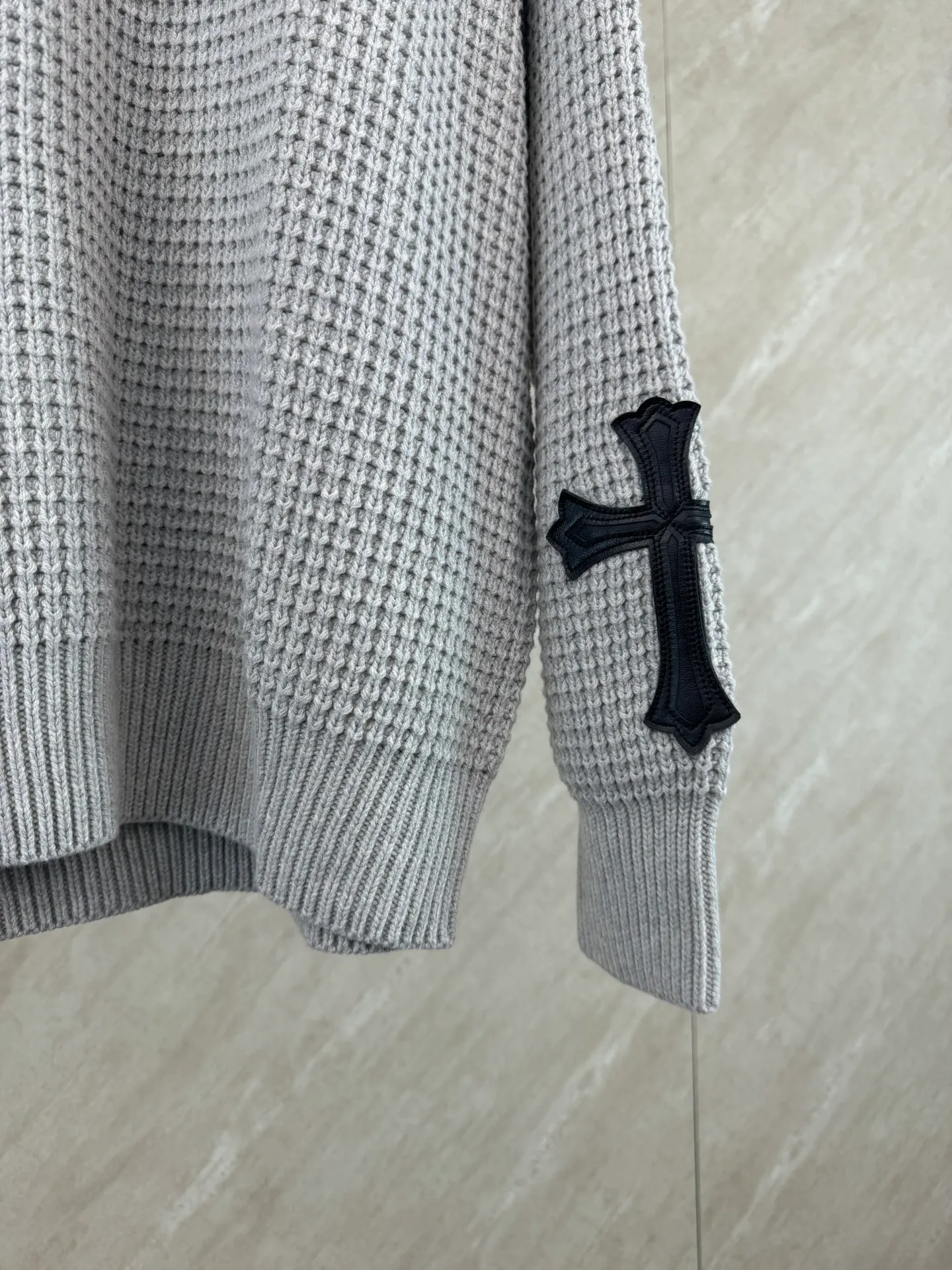 P570 Chrome Hearts cashmere waffle sweater size s m l The main body fabric is made of custom-woven and dyed cashmere and mulberry silk blended yarn. The whole dress takes nearly 200 minutes. The Chrome Hearts cross leather on both sides of the sleeves is genuine sheepskin. The hardware and cross sheepskin are all hand-sewn. The labor cost is extremely high. The back hardware accessories are molded and made to order. They are aged and oxidized.